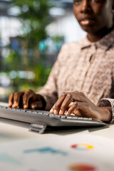 African american businesswoman managing administrative tasks at desk, reviewing organizational performance metrics for success. Skilled manager analyzing data focused on strategic planning.
