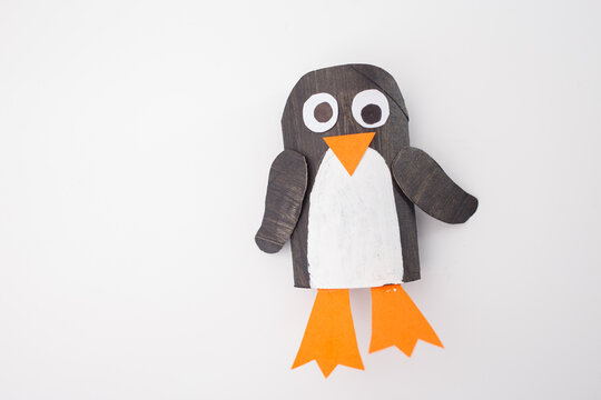 Paper penguin craft in progress, captured from above. A simple yet creative representation suitable for educational resources, craft businesses, and art project inspirations. reuse toilet paper roll