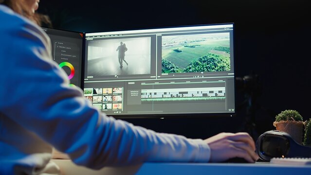 Professional video editor editing color grading and lighting in creative office, analyzing film montage, close up shot. Post production videographer manipulates raw footage, camera B