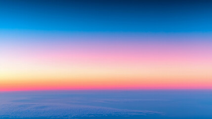 Naklejka premium A serene sky transitions from deep blue to soft pink and orange, creating a peaceful atmosphere above the clouds during sunset.