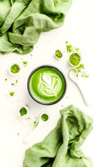 Obraz premium Artistic matcha latte with frothy design surrounded by green tea powder and linen, promoting healthy herbal drinks