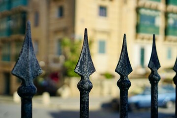 A lit metal fence with spikes. Exterior design. Closeup.