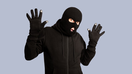Hands Up. Masked looter being arrested by police, posing and standing isolated on white studio...