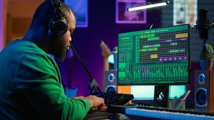 Skilled audio technician editing recorded tracks from an usb stick, using raw files to apply mix...