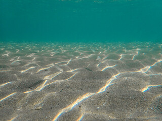Dark blue ocean surface seen from underwater. Abstract waves underwater and rays of sunlight...