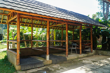 A charming bamboo gazebo provides shade in a vibrant tropical garden. Rustic charm and natural beauty combine. Rustic Bamboo Gazebo in Lush Tropical Setting