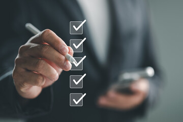 Quality control and check list, Businessman use pen to tick correct sign mark in checkbox for...