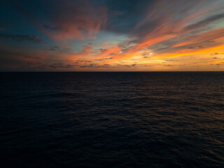 Dark ocean waves under a sky with orange and pink sunset clouds. Seychelles, Mahe.