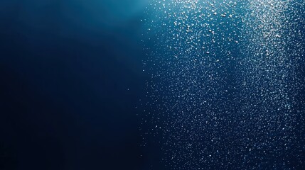 Obraz premium A tranquil underwater scene featuring shimmering particles in blue depths, evoking a sense of calm and mystery.
