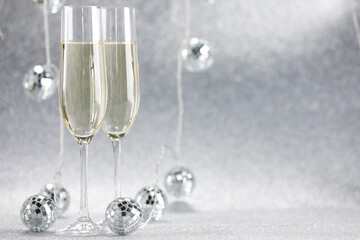 Champagne in glasses and decor on silver background. Space for text
