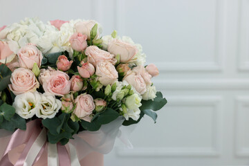Bouquet of beautiful flowers and eucalyptus branches against blurred background, closeup. Space for text