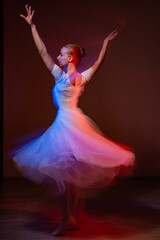 Naklejka premium Caucasian woman dancing classical dance in tutu . Long exposure photo. 