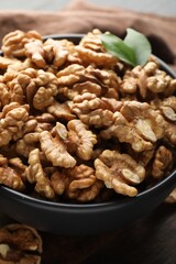 Fresh ripe walnuts in bowl on table, closeup