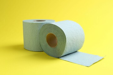 Light blue toilet paper rolls on yellow background
