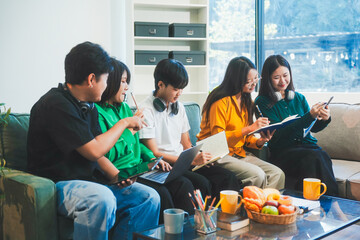 Five young Asian students engage in online study on campus, collaborating on research, projects....
