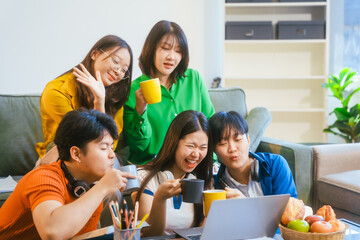 Five young Asian students engage in online study on campus, collaborating on research, projects. They help each other with assignments, gaining valuable experience and preparing for future careers.