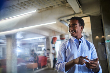Young man using a smart phone while working in a startup company office