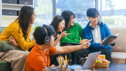 Naklejka premium Five young Asian students engage in online study on campus, collaborating on research, projects. They help each other with assignments, gaining valuable experience and preparing for future careers.
