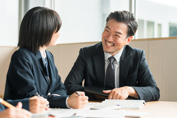 学校の授業・塾で先生・講師・教師から指導を受ける小学生・中学生・高校生・女子高生
