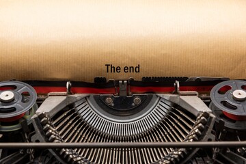Detalle de una vieja máquina de escribir con , the end, escrito en el papel
