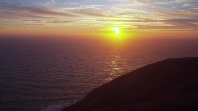 California dreaming sunset on horizon North Cali San Francisco Point Reyes Bodega Bay Sonoma Coast State Park Pacific Ocean dreamy orange yellows clouds mountainside Big Sur Half Moon Bay static shot