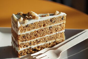 Delicious layer cake served on a plate with a wooden fork