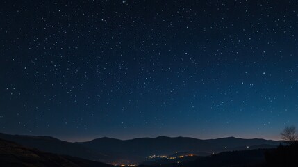 Starry Night Sky Over Mountain Range with Distant City Lights