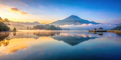Fototapeta premium Serene lake scene at dawn in Bali Indonesia with misty mountains reflecting perfectly on calm waters, dawn, mountains, dawn, mountains