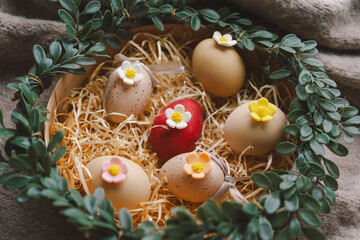 A decorative nest for Easter displays colorful eggs with floral accents, nestled in soft straw and...