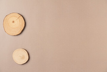 Wooden cross section cut on beige background. Flat lay, top view. Copy space