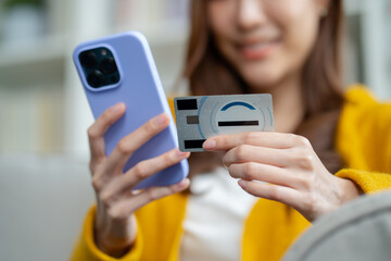 young asian woman smiling happy holding smartphone and credit card at home.asian female online banking transaction,E commerce virtual shopping,secure mobile banking,Pay for goods concept.