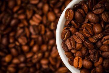 Coffee bens and white cup on the coffee beans Background. background and textures. Shot from above.
