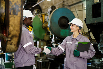 Team of mechanical engineers are performing inspection on heavy machines in workshop - factory.