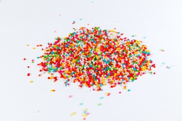 A pile of colorful sprinkles for cake decoration on white background