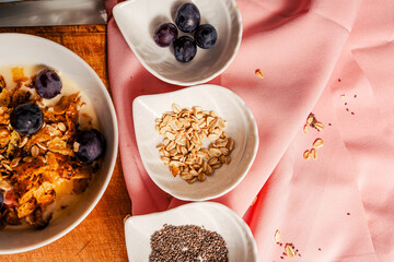 Copy space healthy breakfast with yogurt mixed with homemade granola and fruits: mango, papaya and grapes.