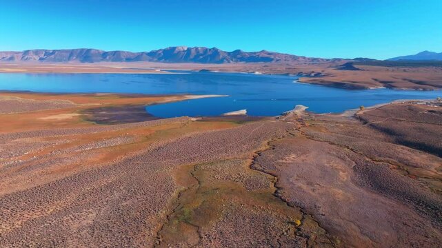 Calm Crowley Lake Stone Columns Marina boats fishing Mammoth Lakes Mountain California aerial drone October Fall autumn morning blue sky Bishop Toms Place Sierra hilltop hot springs forward motion