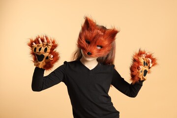 Quadrobics. Girl wearing fox mask and gloves on beige background