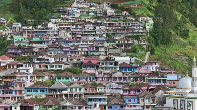 Aerial scenery terraced colorful house of village on hillside. Beautiful Indonesia village of Butuh Village, Nepal Van Java, Mount Sumbing, Magelang. 4K drone view.