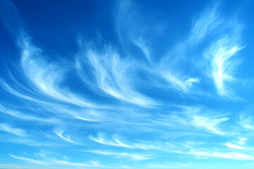 Serene swirls of cirrus clouds drift across a vibrant blue sky, creating a captivating natural backdrop.