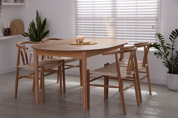 Stylish wooden table with chairs and decor indoors. Interior design
