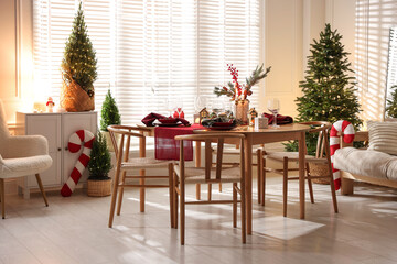 Christmas table setting with stylish dishware and festive decor indoors