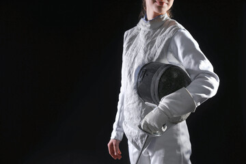 Fencer with epee on black background, closeup. Space for text