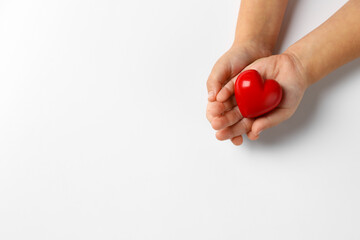 Child holding decorative red heart on white background, top view. Space for text