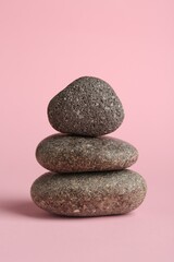 Stack of rocks on light pink background. Harmony and life balance