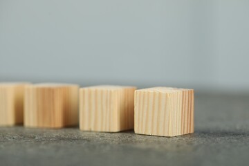 Many wooden cubes on grey table, closeup