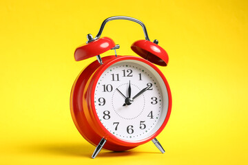 One red alarm clock on yellow background