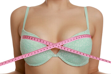 Woman in beautiful bra measuring breast circumference on white background, closeup