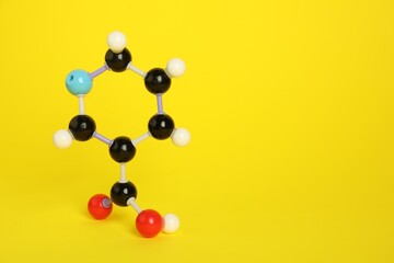 Molecule of niacin (vitamin B3) on yellow background, space for text. Chemical model