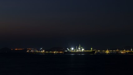 Seascape at night over lighting, crude oil floating station and bridge pipeline load and unloading oil and gas import export transportation global business,