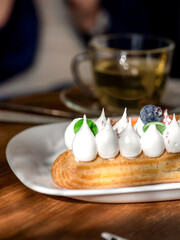 Dessert with whipped cream and blueberries on top sits on a white plate